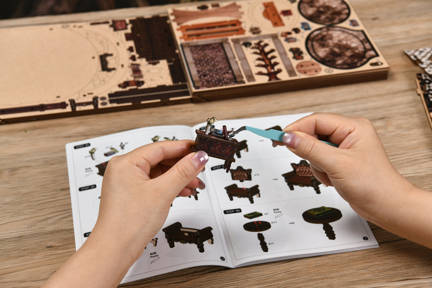 Hands assembling DIY miniature kit parts
